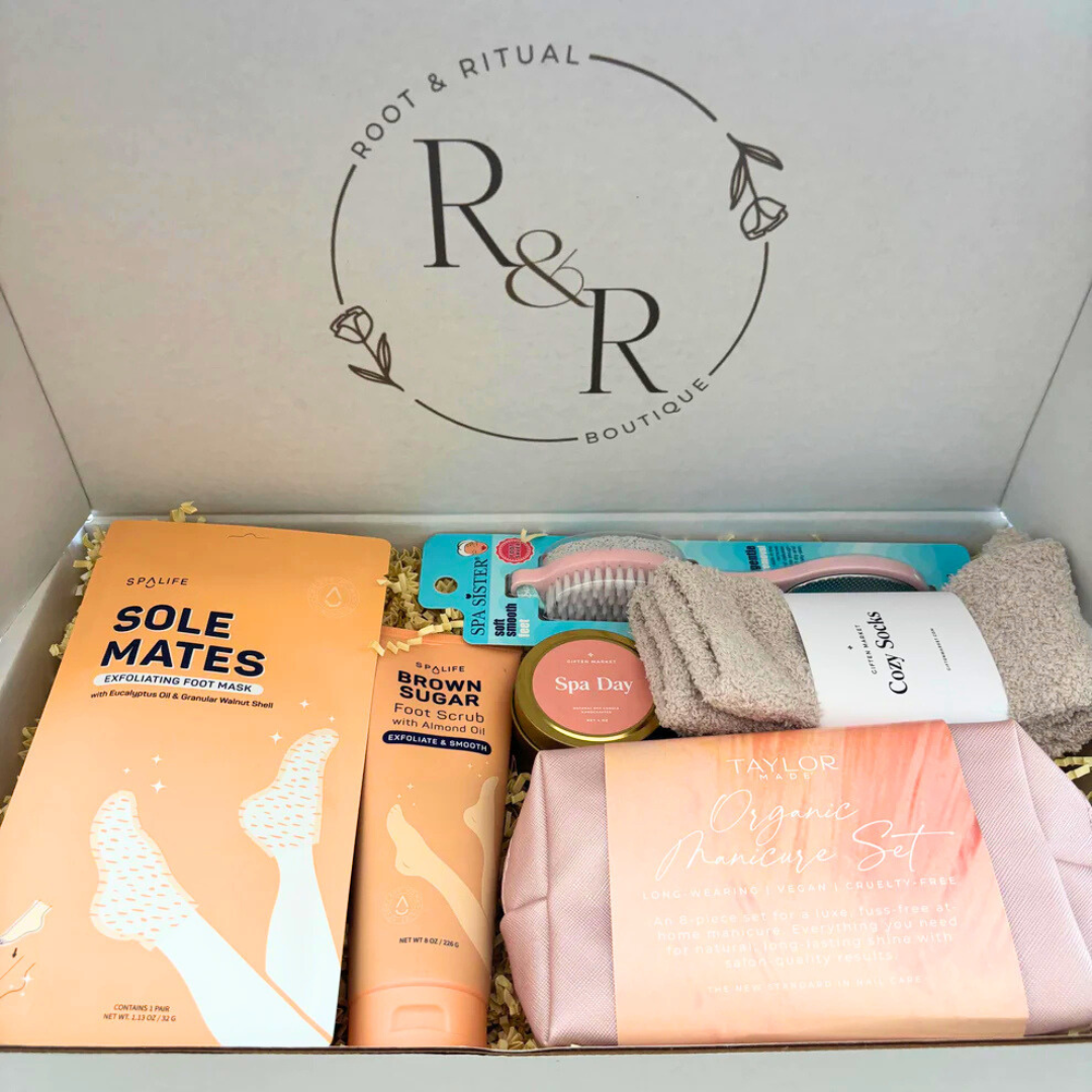 selfcare gift box for nail care including foot mask booties, brown sugar exfoliating foot scrub, spa day soy candle, pedicure foot smoother, cozy socks, organic manicure set (glass nail file, cuticle pusher, hand scrub, base coat, top coat, clear coat, cuticle oil pen, soy nail polish remover, lint free pads, vegan leather rose gold clutch bag)